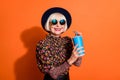 Photo of smiling cheerful good mood happy grandmother hold fizzy drink cola soda isolated on orange color background Royalty Free Stock Photo