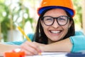 Photo of smiling female engineer wearing orange helmet. Royalty Free Stock Photo