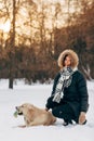 Photo of smiling girl with labrador on background of trees in winter park Royalty Free Stock Photo