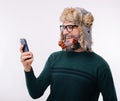 Smiling man with decorated beard in christmas time using his new smartphone Royalty Free Stock Photo