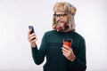 Smiling man using his smartphone and holding cup of coffee to go Royalty Free Stock Photo