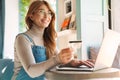 Photo of smiling mature woman holding credit card while using on laptop Royalty Free Stock Photo