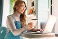 Photo of smiling mature woman holding credit card while using on laptop Royalty Free Stock Photo