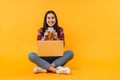 Photo of smiling nice woman holding credit card while sitting on floor