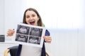 Photo of smiling pregnant woman holding ultrasound result. Royalty Free Stock Photo