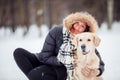 Photo of smiling woman squatting next to labrador in winter Royalty Free Stock Photo