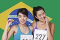 Portrait of smiling young medalists standing against Brazilian flag Royalty Free Stock Photo