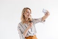 Photo of smiling young woman wearing glasses taking selfie photo and holding paper cup isolated Royalty Free Stock Photo