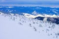 Snowy slope of a mountainous area against the backdrop of mountains