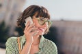 Photo of sociable pretty businesswoman make call have conversation wear glasses striped shirt urban city outside