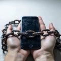 Photo Social media shackles Mobile phone symbolically chained to users hands