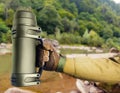 Soldier hand in gloves holding thermos Royalty Free Stock Photo