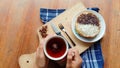 A photo of someone eating a mini martabak and drinking a cup of tea on a wooden table Royalty Free Stock Photo