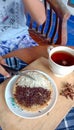 A photo of someone eating a mini martabak and drinking a cup of tea on a wooden table Royalty Free Stock Photo