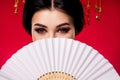 Photo of sophisticated elegant lady hiding face japanese fan traditional isolated on red gradient color background