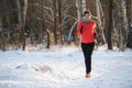 Photo of sports girl on run through winter forest Royalty Free Stock Photo
