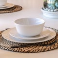 Photo Square Bowl plate and utensils on round placemat against white dining table Royalty Free Stock Photo