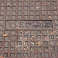 Photo Square Rusty circular utility electric manhole cover amid fresh white snow in winter Royalty Free Stock Photo