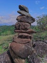 Photo of stack balanced stone at the peak of Maddo Hill, Barru, South Sulawesi, Indonesia with a beautiful landscape at noon.