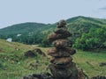 Photo of stack balanced stone at the peak of Maddo Hill, Barru, South Sulawesi, Indonesia with a beautiful mountain background.