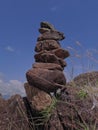 Photo of stack balanced stone at the peak of Maddo Hill, Barru, South Sulawesi, Indonesia with a blue skies background at noon.
