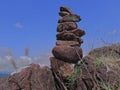 Photo of stack balanced stone at the peak of Maddo Hill, Barru, South Sulawesi, Indonesia with a blue skies background at noon.