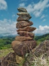 Photo of stack balanced stone at the peak of Maddo Hill, Barru, South Sulawesi, Indonesia. Low angle shot.