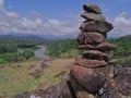 Photo of stack balanced stone at the peak of Maddo Hill, Barru, South Sulawesi, Indonesia with a river and beautiful landscape.