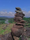 Photo of stack balanced stone at the peak of Maddo Hill, Barru, South Sulawesi, Indonesia with a river and beautiful landscape. Royalty Free Stock Photo