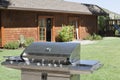 Stainless steel barbecue grill in front of house at lawn