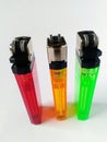 Photo of standing three plastic lighters. Red, yellow and green.