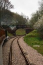 A photo of a steam train before it passes under a bridge