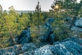 Photo from the steep slope of the Northern Scandinavian forest in rocky mountains, big stones, yellow green trees at the end of Royalty Free Stock Photo