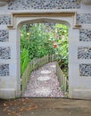 Stone arch gateway door entrance to beautiful garden flowers plants Royalty Free Stock Photo