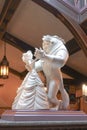 A photo of Stone Sculpture of Disney princess Belle and the Beast dancing together.