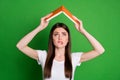 Photo of stressed cute brunette hair young lady hold book above head wear white t-shirt isolated on green color