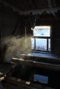 Photo of a strip shed in the city of Kargopol, Arkhangelsk region. Walls, beams and window inside are covered with a web of snow c