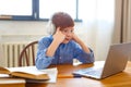 Photo of a student during an online lesson. He sits in headphones and listens to a boring lesson topic.