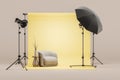 Photo studio with yellow cyclorama and armchair, soft box on tripod