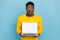 Photo of stunned guy hold new model laptop sale price offer wear long sleeve nice pullover isolated blue color