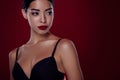 Photo of stunning asian woman femme fatale look empty space black bra shoulders off  dark red color background Royalty Free Stock Photo