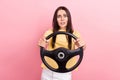 Photo of stupor confused woman dressed yellow t-shirt riding car stuck in traffic jam isolated pink color background