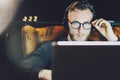 Photo stylish bearded man wearing glasses working modern loft office. Young banker sitting vintage chair,listening music Royalty Free Stock Photo