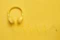 Photo of stylish yellow headphone on yellow background. Music concept.