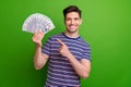 Photo of successful positive guy with stubble dressed striped t-shirt directing at money get bonus isolated on green Royalty Free Stock Photo