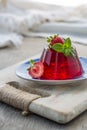 Photo of summer Jelly Dessert with strawberry. Garnished with a sprig of fresh basil on light background. Royalty Free Stock Photo