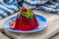 Photo of summer Jelly Dessert with strawberry. Garnished with a sprig of fresh basil on light background. Royalty Free Stock Photo