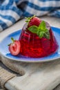 Photo of summer Jelly Dessert with strawberry. Garnished with a sprig of fresh basil on light background. Royalty Free Stock Photo