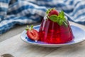 Photo of summer Jelly Dessert with strawberry. Garnished with a sprig of fresh basil on light background. Royalty Free Stock Photo