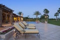 Sun loungers in patio at poolside outside luxurious manor house